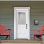  The porch features a white door and two striking red chairs, inviting relaxation and a sense of home.