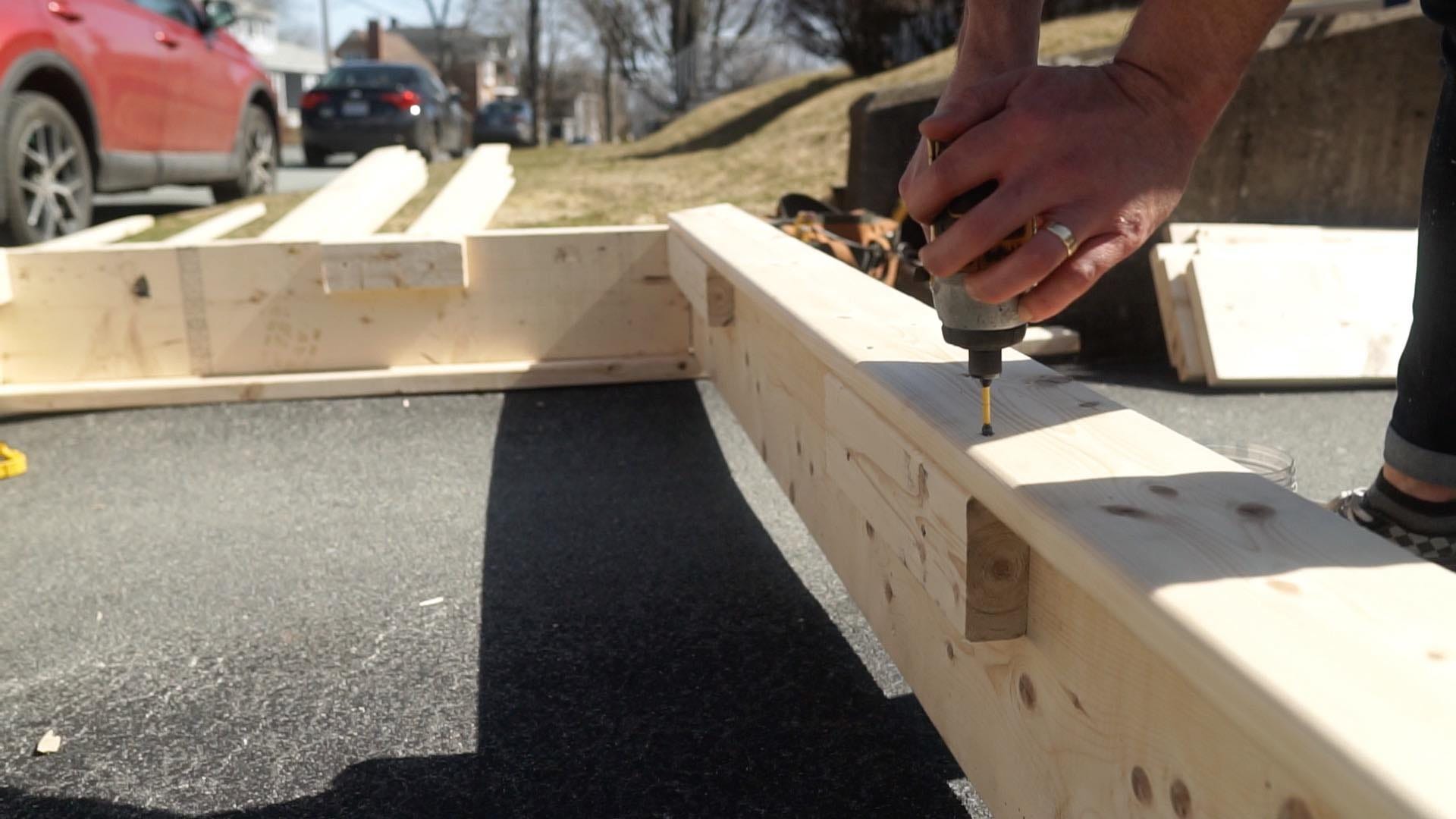 person fastening boards together