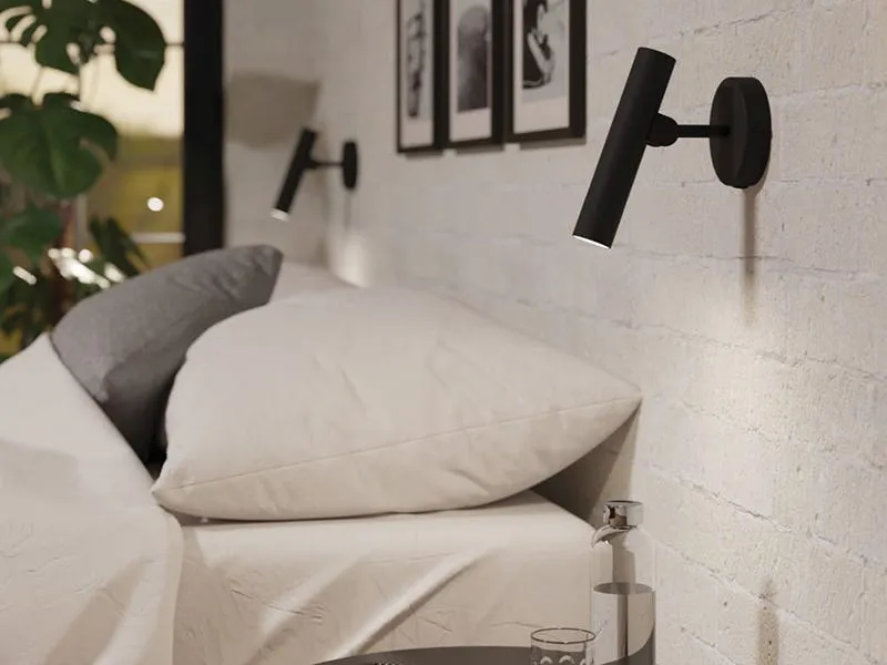 Cozy bedroom with two black cylindrical wall-mounted reading lights