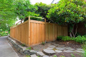 A sturdy cedar fence in a suburban setting A sturdy cedar fence in a suburban setting, highlighting the craftsmanship and adding charm to the residential landscape.