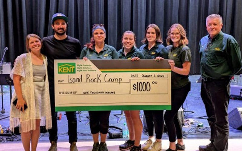 Les associés de KENT affichent fièrement un chèque de 5 000 $ pour le camp de charité, célébrant leur réussite ensemble