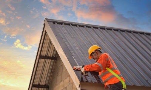 Man on a ladder on a metal roof